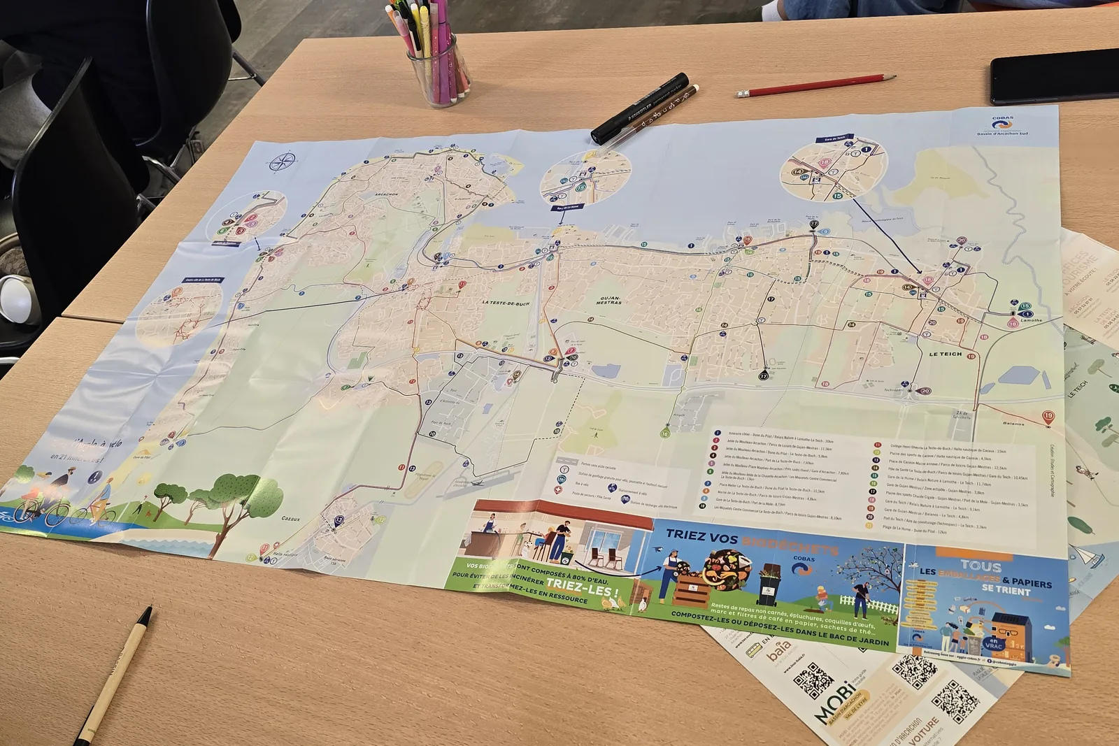 Carte des déplacements du Bassin d’Arcachon dépliée sur une table, avec feutres et crayons, pendant un atelier mobilité.