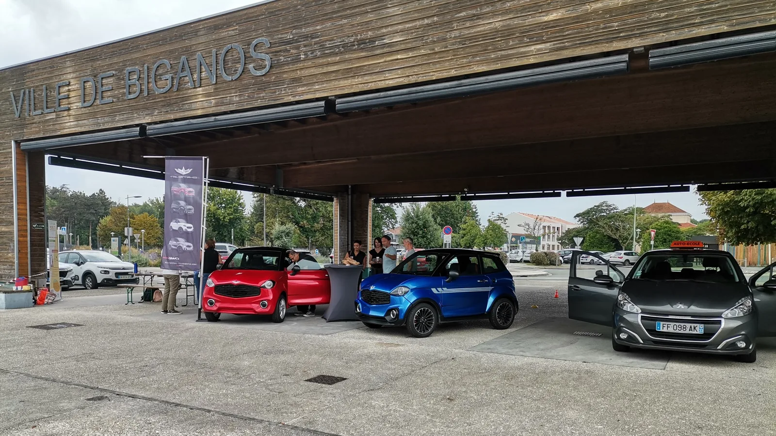 Sous la halle de Biganos, deux voitures sans permis exposées au forum de la mobilité de septembre 2023.
