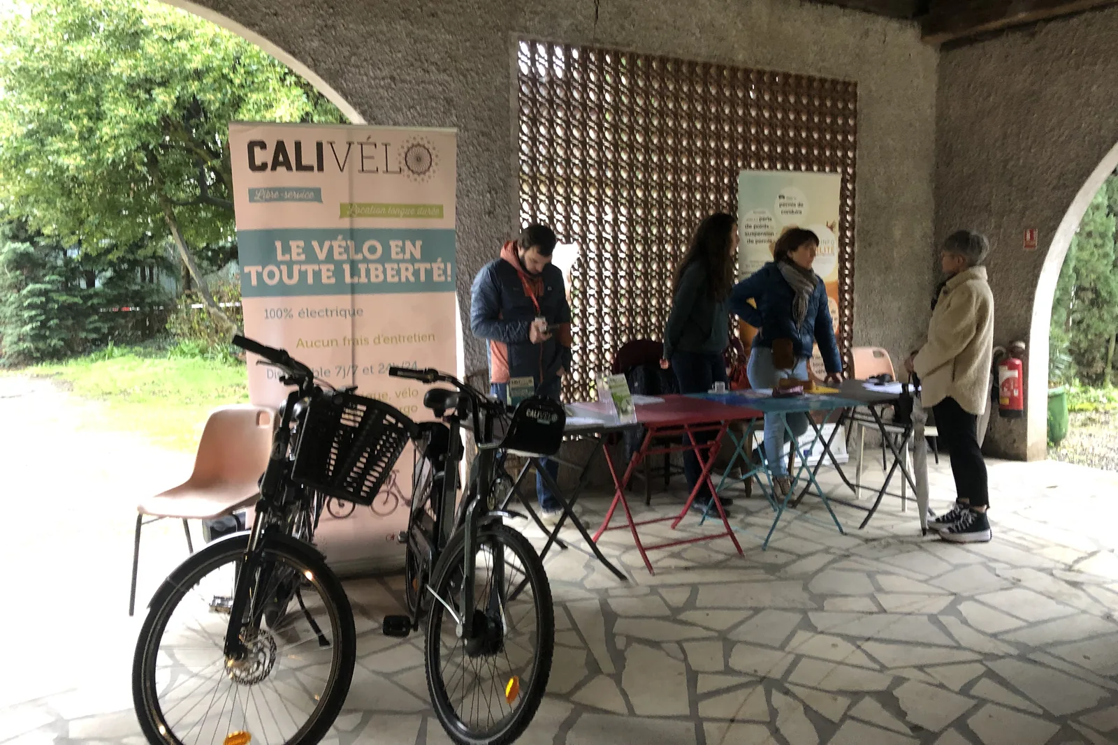 Stand Cali Vélo sous une halle : deux vélos électriques à panier devant un kakémono « Le vélo en toute liberté ».