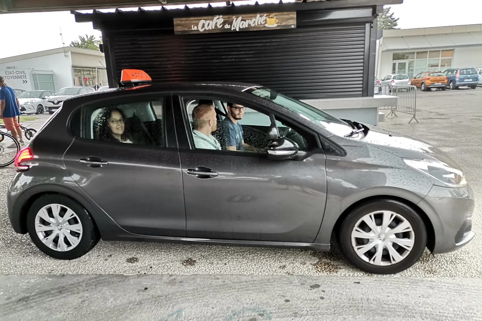 Une voiture d’auto-école avec son moniteur et des passagers, pendant les essais du forum de la mobilité.